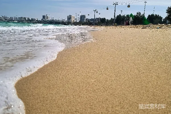 沙滩旁的海洋下有着一片晴朗天空下的沙地