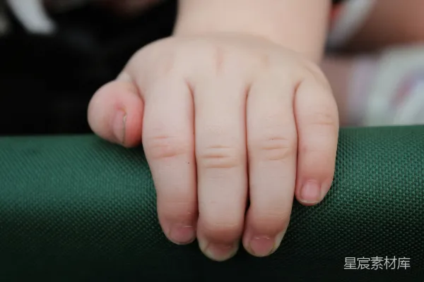 高清摄影 一个孩子手的特写镜头放在绿色的椅子上
