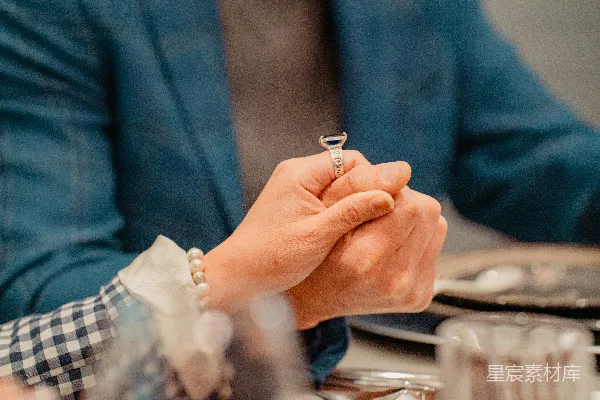 高清摄影 一个人坐在桌子旁拿着一枚戒指
