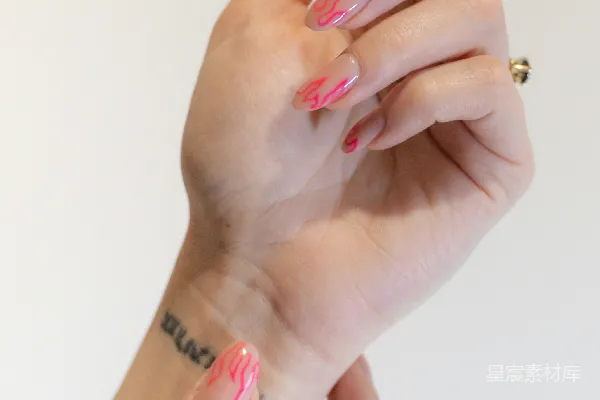 高清摄影 一个女子的手，带着粉色和白色的 manicure。