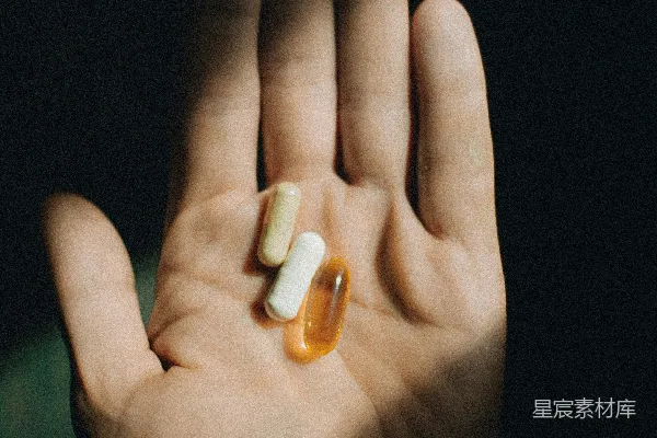 高清摄影 一只手拿着两片药，在黑暗中