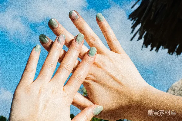 高清摄影 一个女子的手上涂着绿色的指甲油