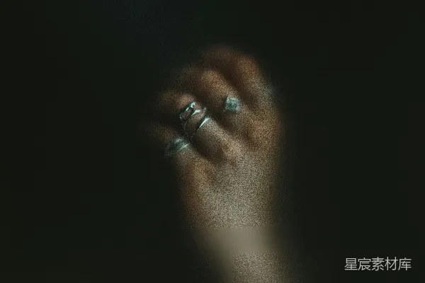 高清摄影 一个女人的手拿着一枚戒指，在黑暗中。