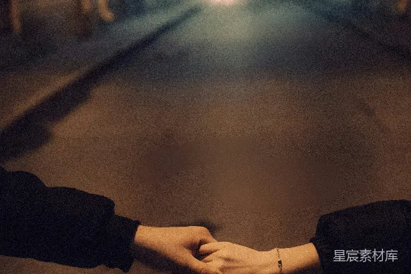 高清摄影 一对人在城市街道上手牵手，夜幕低垂。