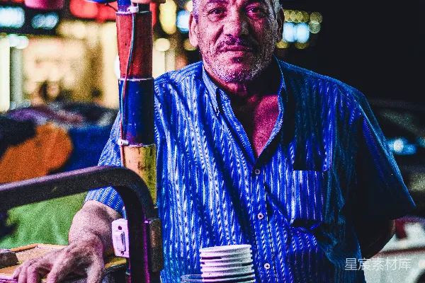 高清摄影 一个身穿紫色头发和胡子的人手持一叠啤酒罐