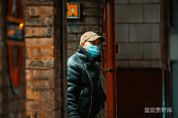 高清摄影 黑色夹克和棕色针织帽的男人站在一扇棕色木门前。