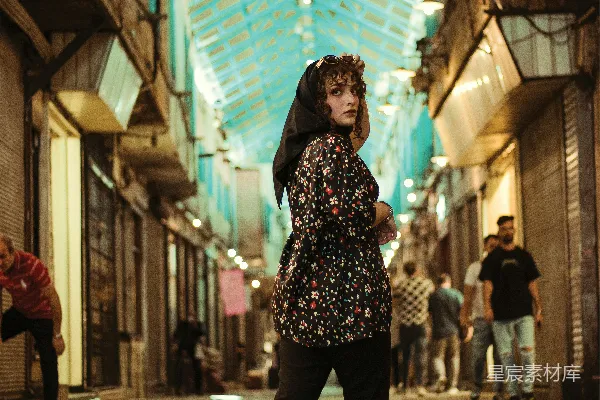 高清摄影 一位女性站在铺有瓷砖的地面上，位于一栋建筑中。
