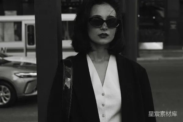 高清摄影 一个女人站在路边靠近一根电线杆。
