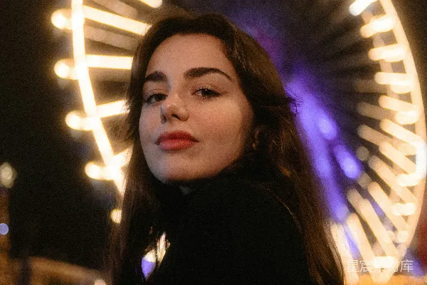 高清摄影 夜晚，一位女性站在 Ferris 小轮前。