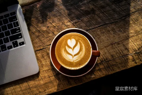 高清摄影 白瓷杯中caffè latte旁边是银色和黑色的笔记本电脑