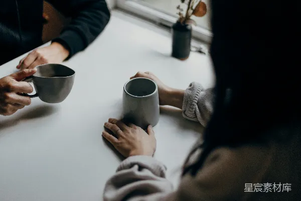 高清摄影 两个人手持灰色马克杯在桌旁