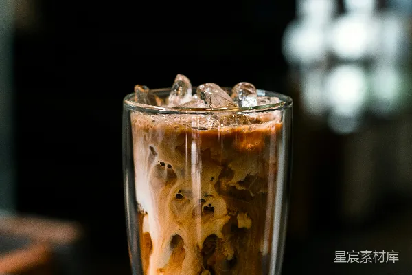 高清摄影 桌子上装有一杯液体和冰块的玻璃杯