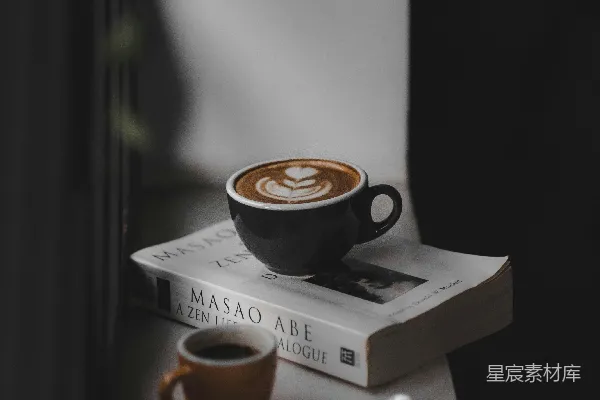 高清摄影 拿铁咖啡液满的黑茶杯置于棕色茶杯旁，棕色茶杯靠近窗户上