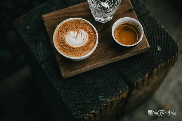 高清摄影 白瓷杯中盛满咖啡，旁边有一玻璃杯装水。