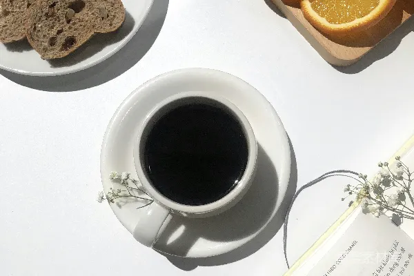 高清摄影 杯中咖啡靠近面包和橙子