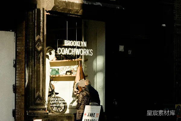 一个女人走在街上，走过一家店铺。
