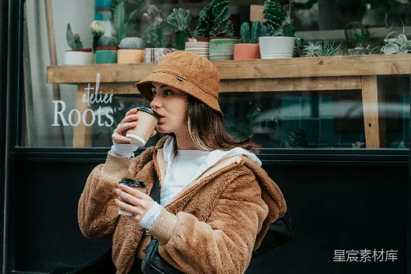 高清摄影 穿棕色风衣的女人手持白色陶瓷杯