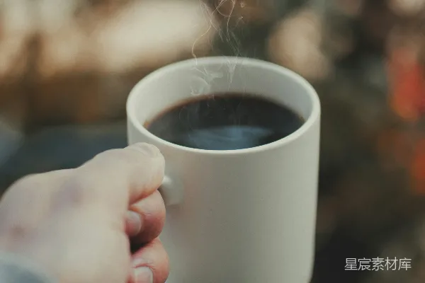 高清摄影 手持白色陶瓷 mug 的人手中拿着棕色液体
