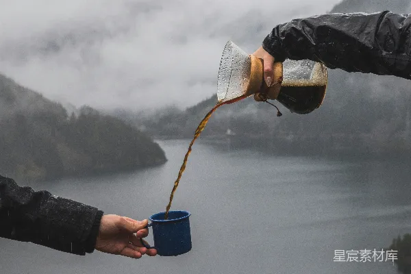高清摄影 一个人将咖啡倒入另一个人的杯中，地点靠近水面