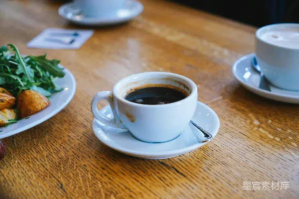 高清摄影 桌子上放着一杯咖啡和一盘食物。