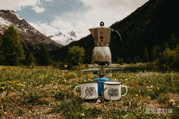 高清摄影 灰色不绣钢摩 Kopf 在两杯白咖啡之间绿色草地上，放在烧水壶上。
