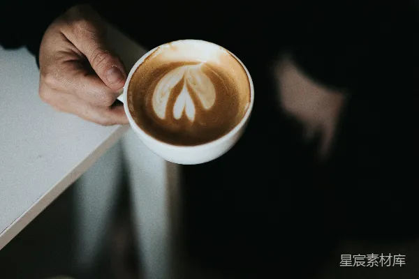 高清摄影 手持白色陶瓷杯的人手中握着一杯棕色液体