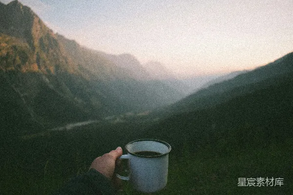 高清摄影 山间持杯的人手中握着一杯咖啡。