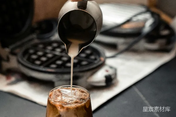 高清摄影 一个人将咖啡倒入玻璃杯中。