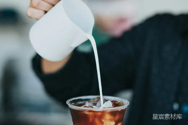 高清摄影 聚焦于手持杯并往塑料杯中加奶油的人的选拍摄法