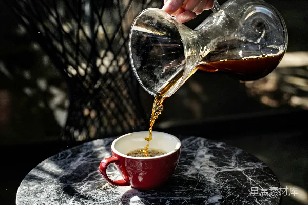 高清摄影 咖啡正在倒入一个红色的杯子中。