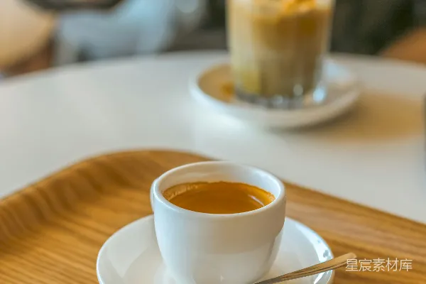 高清摄影 一个坐在桌子旁的人，手中拿着一杯咖啡。