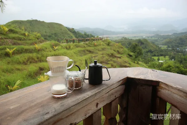 高清摄影 桌子上有杯子和茶杯，背景是草坡。