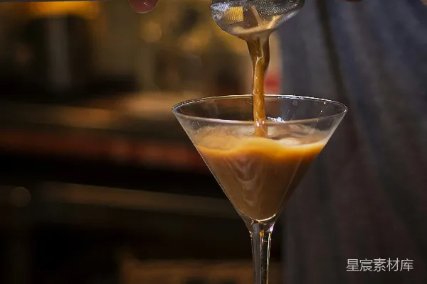高清摄影 有人将黄色液体倒入调酒杯中