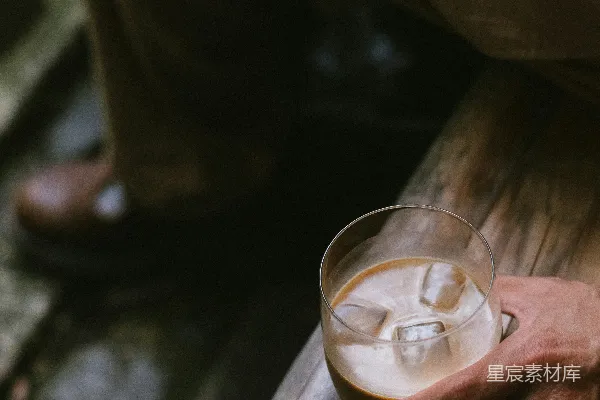 高清摄影 桌子上一个人拿着一杯液体上方