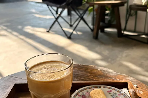 高清摄影 户外木制托盘上的一杯咖啡和一块饼干。