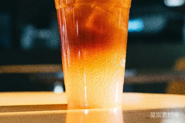高清摄影 一款 layered 冰咖啡饮料，装在透明塑料杯中。