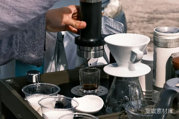 高清摄影 咖啡师正在使用便携式 espresso maker 准备咖啡。