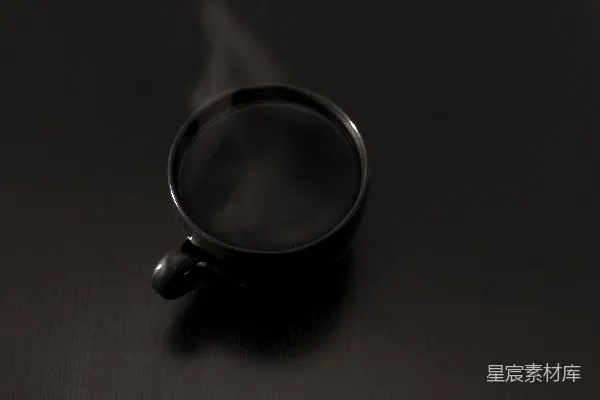 高清摄影 黑暗表面蒸腾着一杯咖啡。