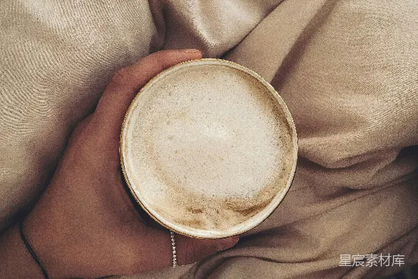 高清摄影 手持白色陶瓷杯的人，杯中盛有棕色液体。
