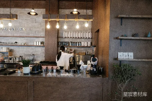高清摄影 咖啡店柜台后，barista正在准备饮品。