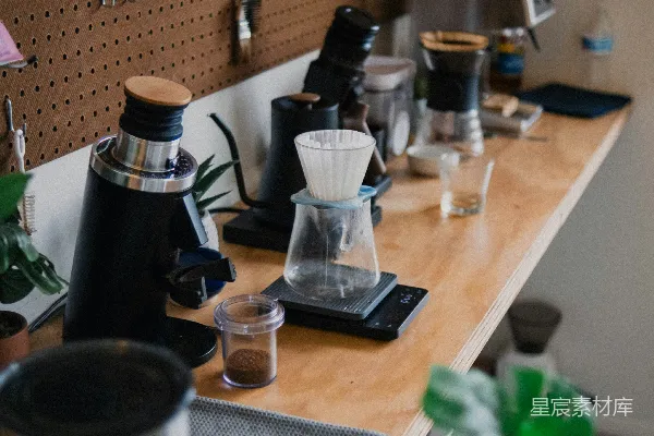 高清摄影 现代咖啡冲煮站配有磨豆机、滴漏设备和绿色植物。