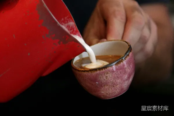 高清摄影 一个人将牛奶倒入一个红色的杯子中