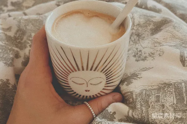 高清摄影 一个手持咖啡杯的人坐在床上