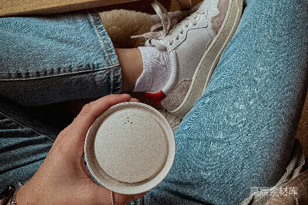 高清摄影 一个坐在地上的人员正在拿着一杯咖啡。