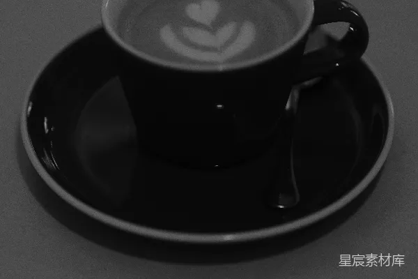 高清摄影 一款黑白相间的咖啡杯，上面装饰有拿铁艺术。