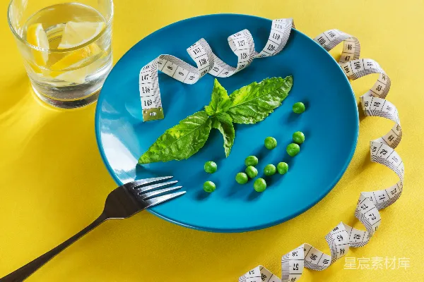高清摄影 一片蓝色的盘子上放着绿色的蔬菜和一个卷尺