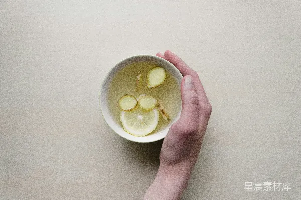 高清摄影 手持装有切片姜和青柠的白色碗的人