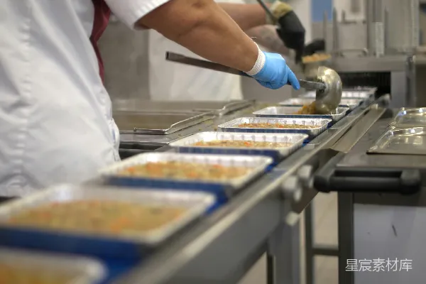 高清摄影 工人正在传送带上填装食品托盘。