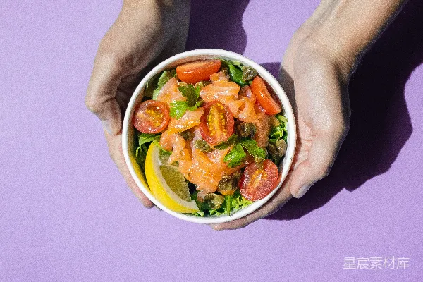 高清摄影 一个手持一碗食物的人在紫色背景上