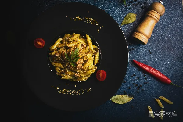 高清摄影 一块黑色的盘子上放着意面，旁边放着胡椒瓶。